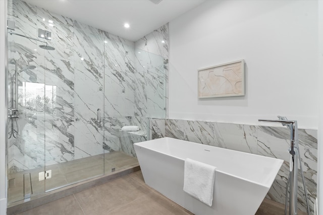 bathroom featuring separate shower and tub and tile walls