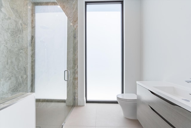 bathroom featuring a shower with door, vanity, tile patterned floors, and toilet