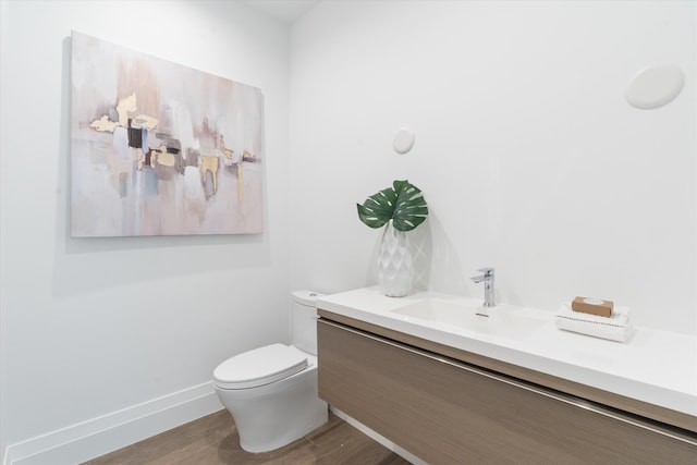 bathroom with hardwood / wood-style floors, vanity, and toilet