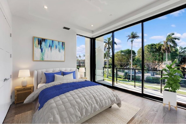 bedroom featuring hardwood / wood-style flooring, access to outside, and floor to ceiling windows