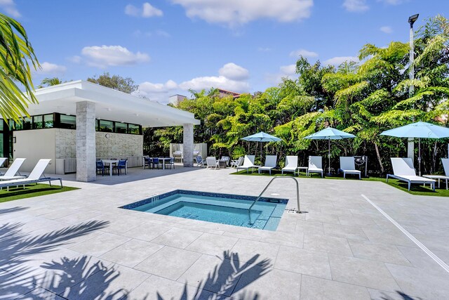 view of swimming pool featuring a community hot tub and a patio