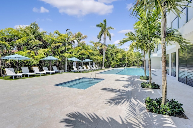 view of swimming pool with a hot tub and a patio area