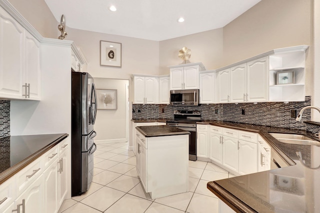 kitchen with white cabinetry, backsplash, stainless steel appliances, light tile floors, and sink