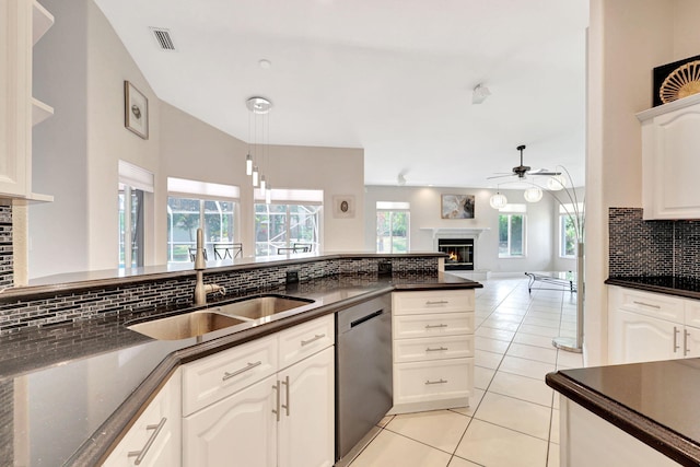 kitchen featuring backsplash, light tile flooring, dishwasher, and white cabinets