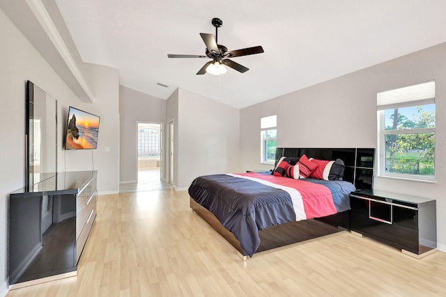 bedroom featuring lofted ceiling, light hardwood / wood-style flooring, ceiling fan, and multiple windows