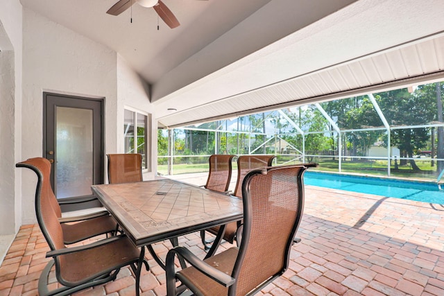 view of swimming pool featuring a patio area, ceiling fan, and glass enclosure