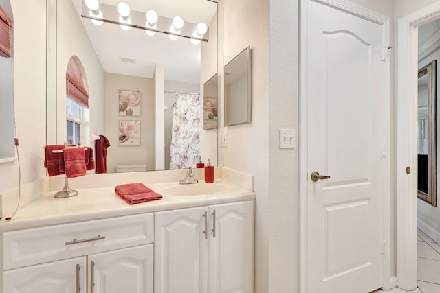 bathroom featuring toilet, tile flooring, and vanity