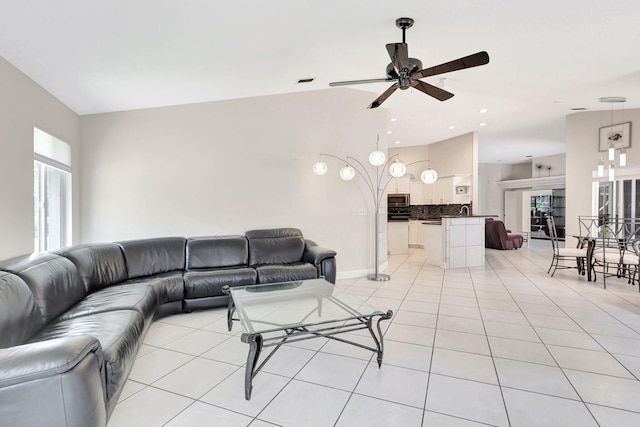 living room featuring sink, ceiling fan, and light tile floors