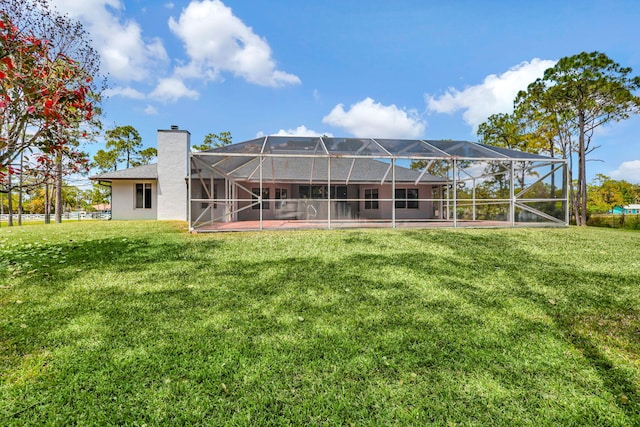 rear view of property with a lanai and a lawn