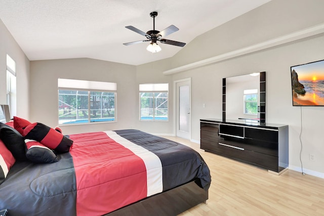 bedroom with lofted ceiling, light hardwood / wood-style flooring, ceiling fan, and multiple windows