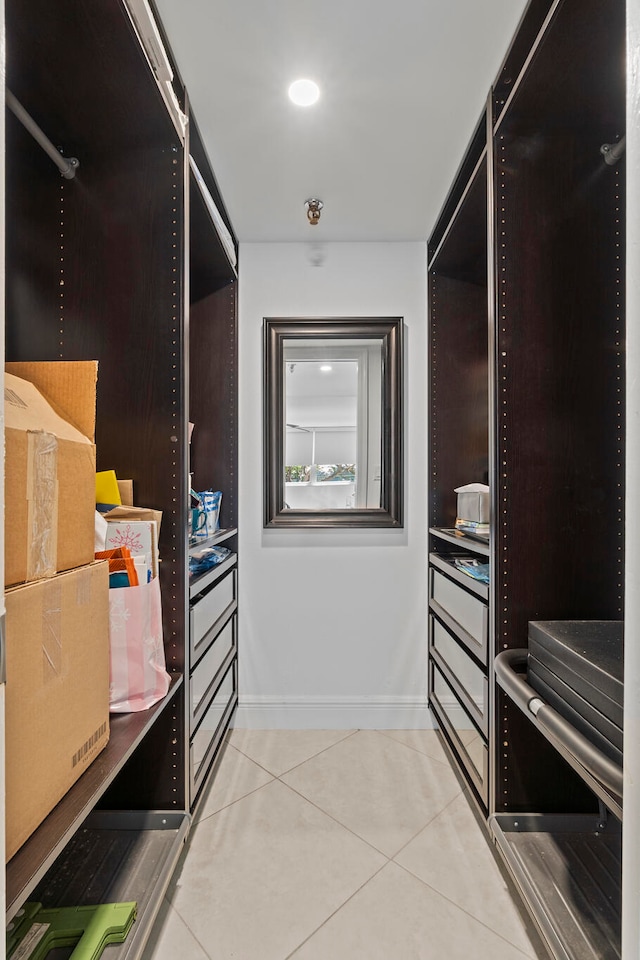 walk in closet with light tile floors