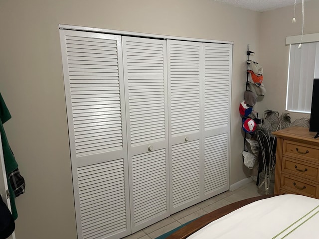 bedroom with tile flooring and a closet