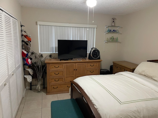 tiled bedroom featuring a closet and a textured ceiling