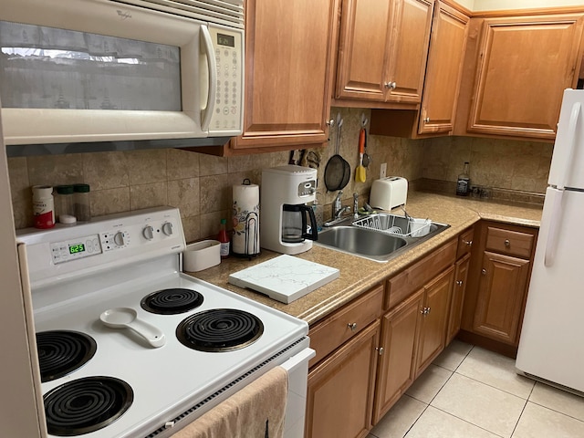 kitchen with tasteful backsplash, white appliances, sink, and light tile flooring