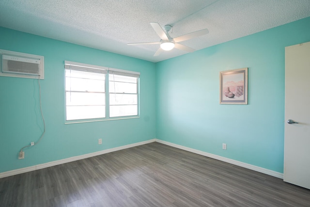 empty room featuring a textured ceiling, dark wood-type flooring, ceiling fan, and an AC wall unit