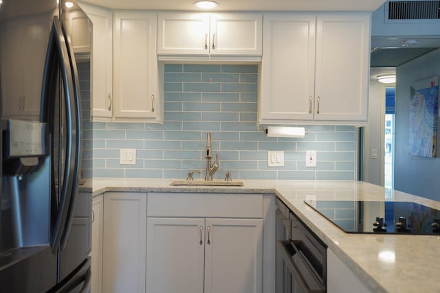 kitchen featuring white cabinetry, black appliances, sink, and tasteful backsplash