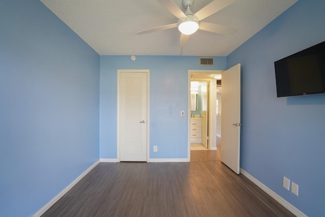 unfurnished bedroom featuring ceiling fan, a closet, a textured ceiling, and wood-type flooring