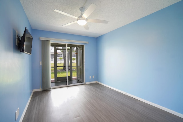 spare room with dark wood-type flooring, ceiling fan, and a textured ceiling