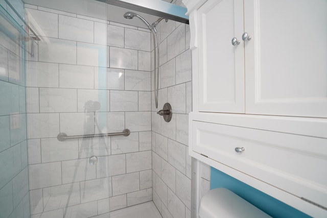 bathroom featuring tiled shower and toilet