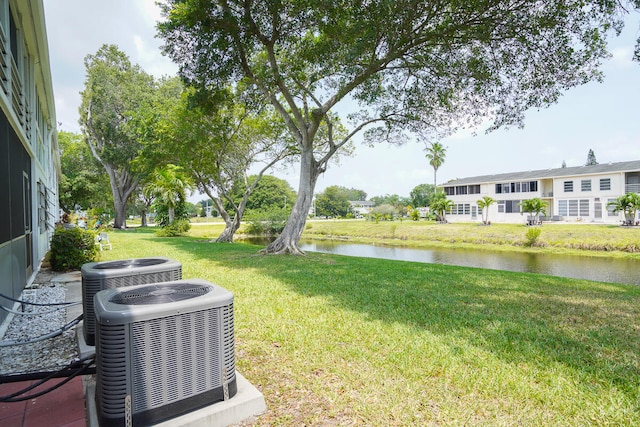 view of yard featuring a water view and central air condition unit