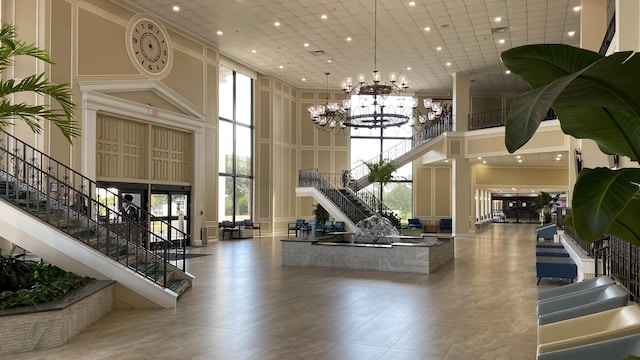 exercise room featuring a high ceiling, an inviting chandelier, and tile floors