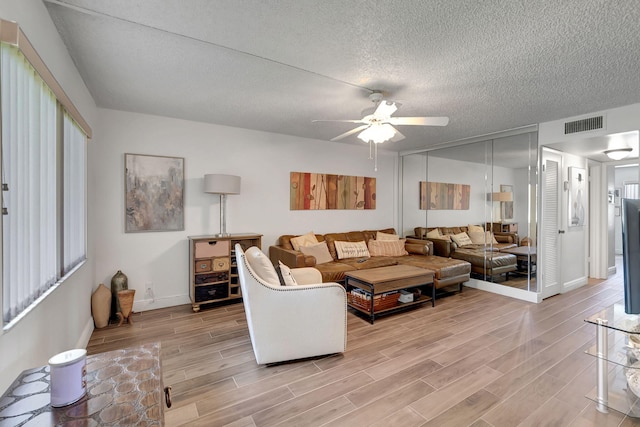 66 Capri B, Delray Beach, FL 33484 - living room with light wood-type flooring, a textured ceiling, a ceiling fan, and baseboards