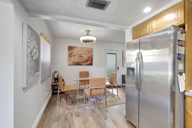66 Capri B, Delray Beach, FL 33484 - dining area featuring a textured ceiling, baseboards, and light wood-style floors