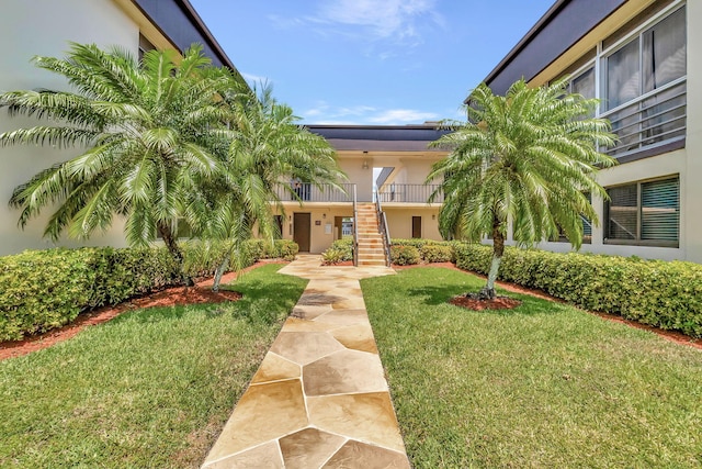 66 Capri B, Delray Beach, FL 33484 - view of front of house featuring stairs, a front yard, and stucco siding