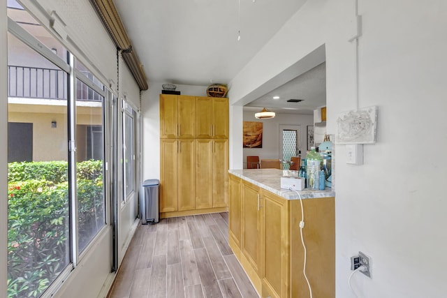 66 Capri B, Delray Beach, FL 33484 - kitchen with healthy amount of natural light, light countertops, light wood-style floors, and light brown cabinets