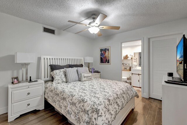 66 Capri B, Delray Beach, FL 33484 - bedroom with dark wood-style flooring, a textured ceiling, a ceiling fan, and connected bathroom