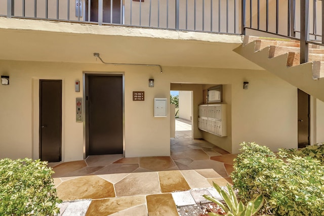 66 Capri B, Delray Beach, FL 33484 - doorway to property with elevator, board and batten siding, and stucco siding