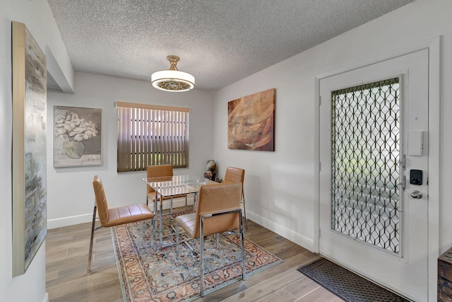 66 Capri B, Delray Beach, FL 33484 - dining area with a textured ceiling, wood finished floors, and baseboards