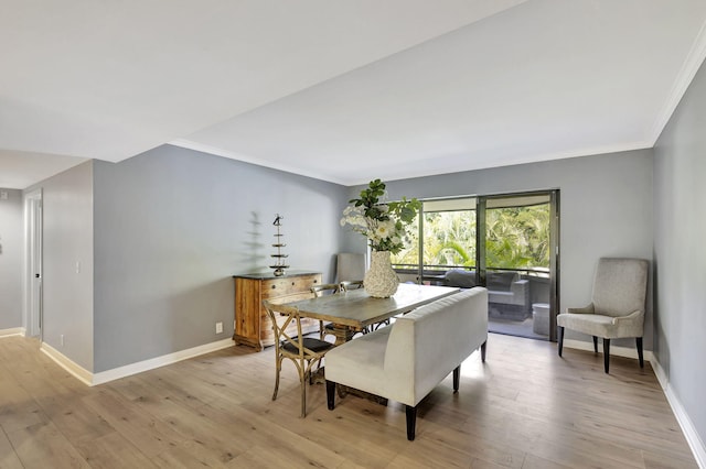 dining area featuring ornamental molding and light hardwood / wood-style floors