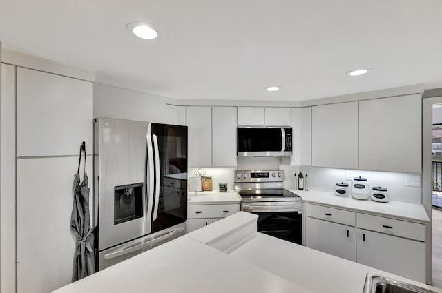 kitchen with white cabinets, appliances with stainless steel finishes, and light hardwood / wood-style flooring