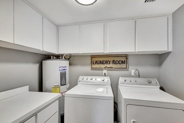 washroom with electric dryer hookup, water heater, washing machine and dryer, and cabinets