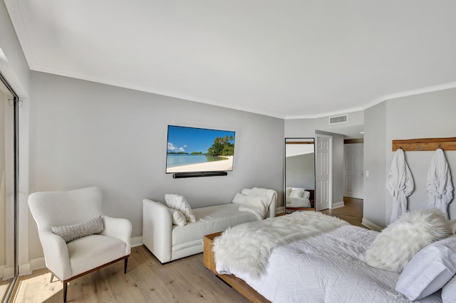 bedroom featuring crown molding and wood-type flooring