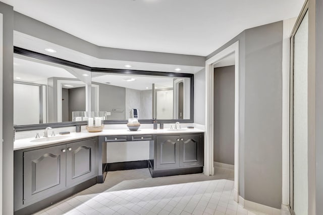 bathroom featuring tile flooring, dual sinks, oversized vanity, and an enclosed shower