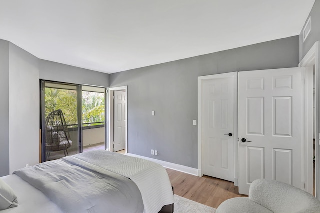 bedroom featuring light wood-type flooring and access to outside