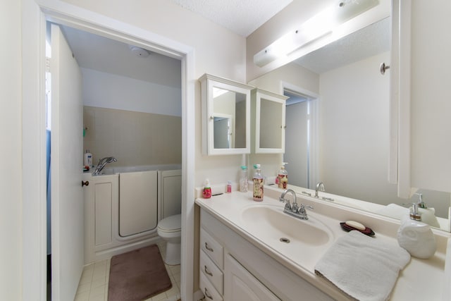 bathroom featuring a textured ceiling, large vanity, toilet, and tile flooring