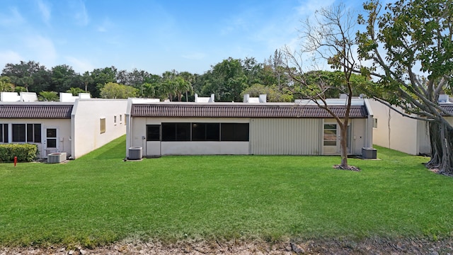 back of property featuring a lawn and central air condition unit