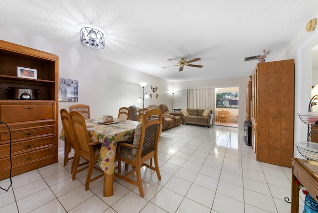 dining room featuring ceiling fan, light tile floors, and a textured ceiling