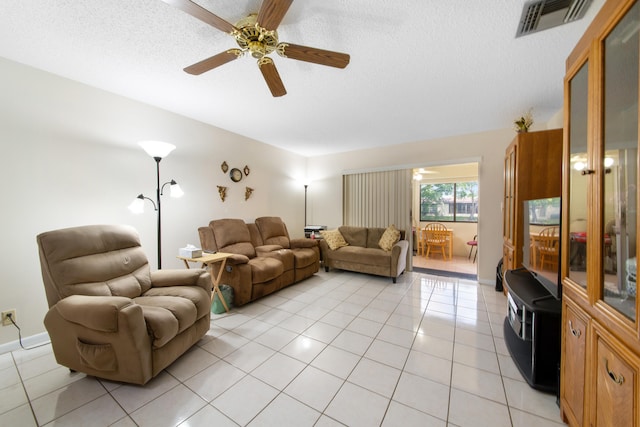 tiled living room featuring ceiling fan and a textured ceiling