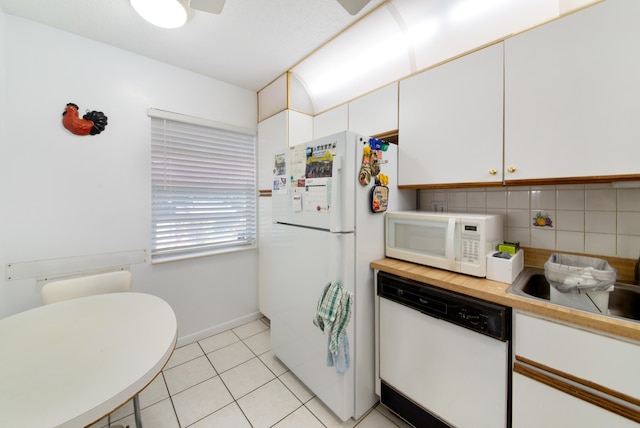 kitchen with white cabinets, white appliances, tasteful backsplash, and light tile floors