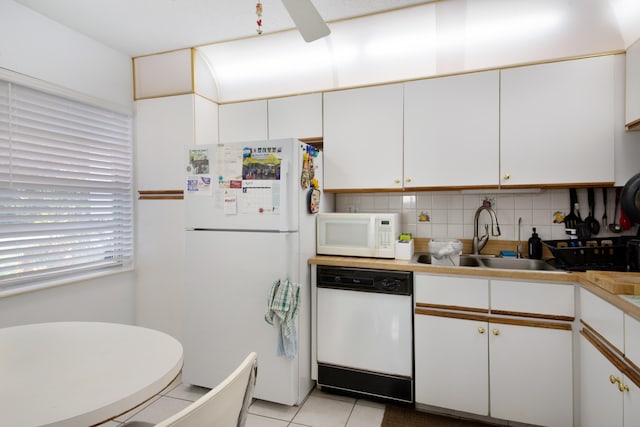 kitchen featuring white cabinets, white appliances, backsplash, light tile floors, and sink