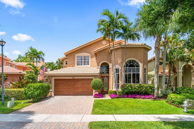 mediterranean / spanish-style house featuring a garage and a front yard