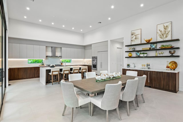 dining area featuring a high ceiling and light tile patterned floors