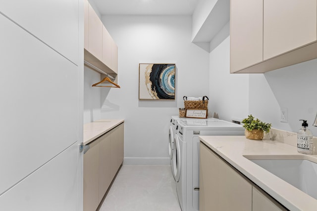 laundry area featuring independent washer and dryer, cabinets, and sink