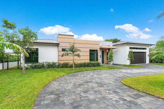 view of front of property featuring a garage and a front yard