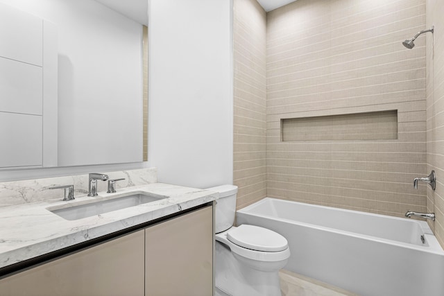 full bathroom featuring tiled shower / bath, vanity, and toilet