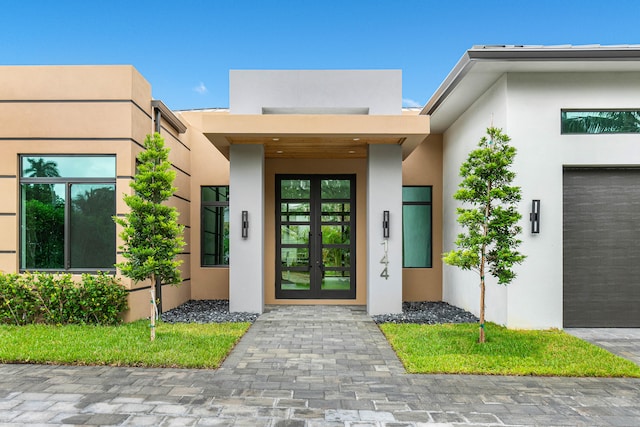 property entrance featuring a garage and french doors